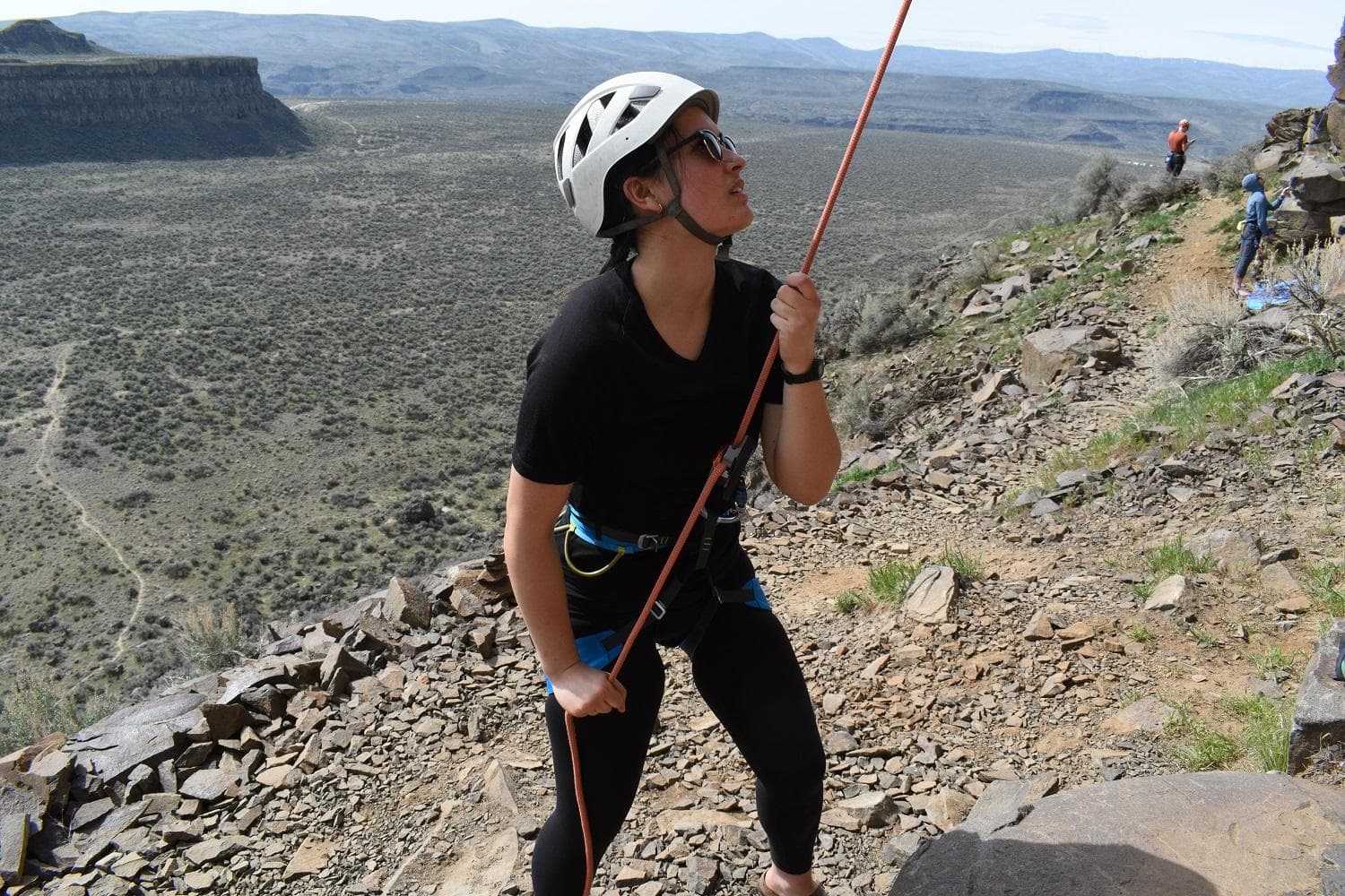 A belayer is ready to catch the climber if they fall
