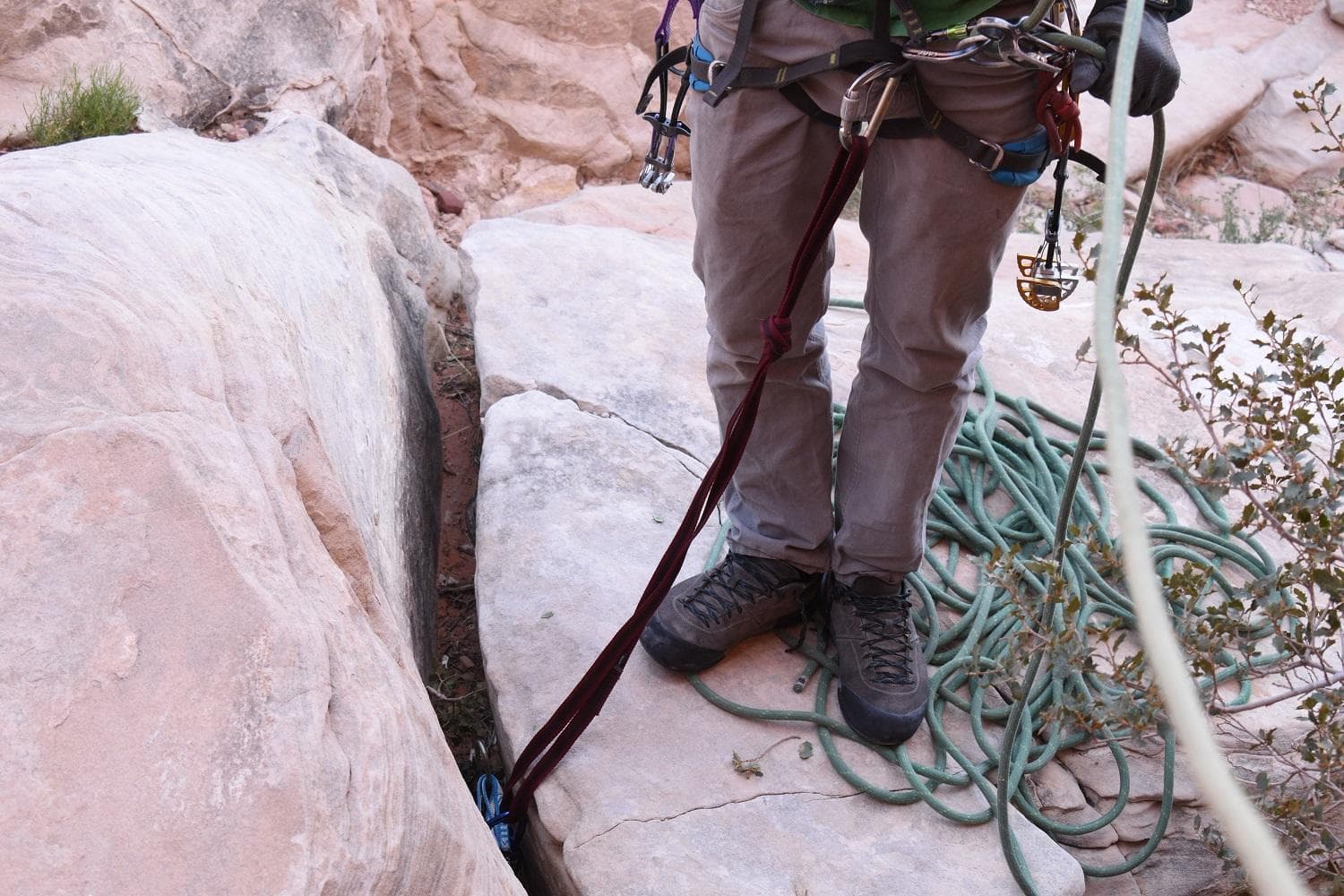 A ground anchor for the belayer helps prevent a rope team from tumbling down a hill